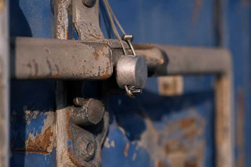 Plombage metallique de securite serti sur la barre de fermeture d'un conteneur maritime