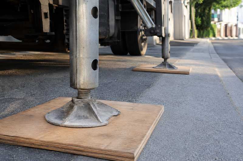 Verins stabilisateurs d'un monte-meuble poses sur des plaques de repartition en bois