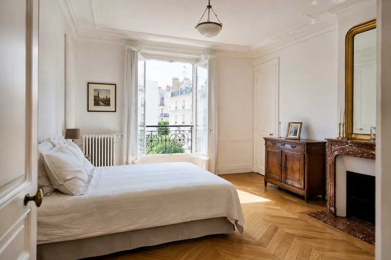 Chambre d'etablissement claire ou un petit buffet ancien a ete installe contre le mur