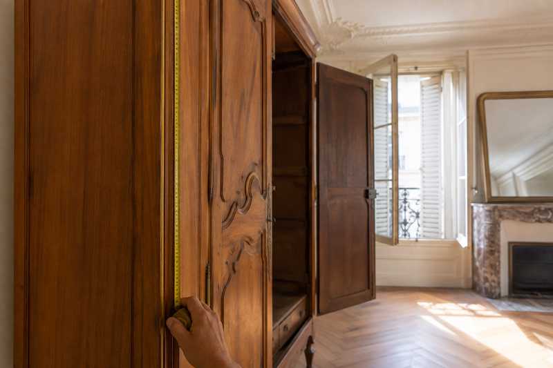 Metre ruban deroule le long du montant d'une armoire ancienne dans une piece a demi vide